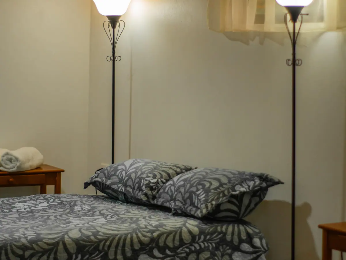 Vista cercana de la ropa de cama y la lámpara de lectura en el Pizote Apartment
