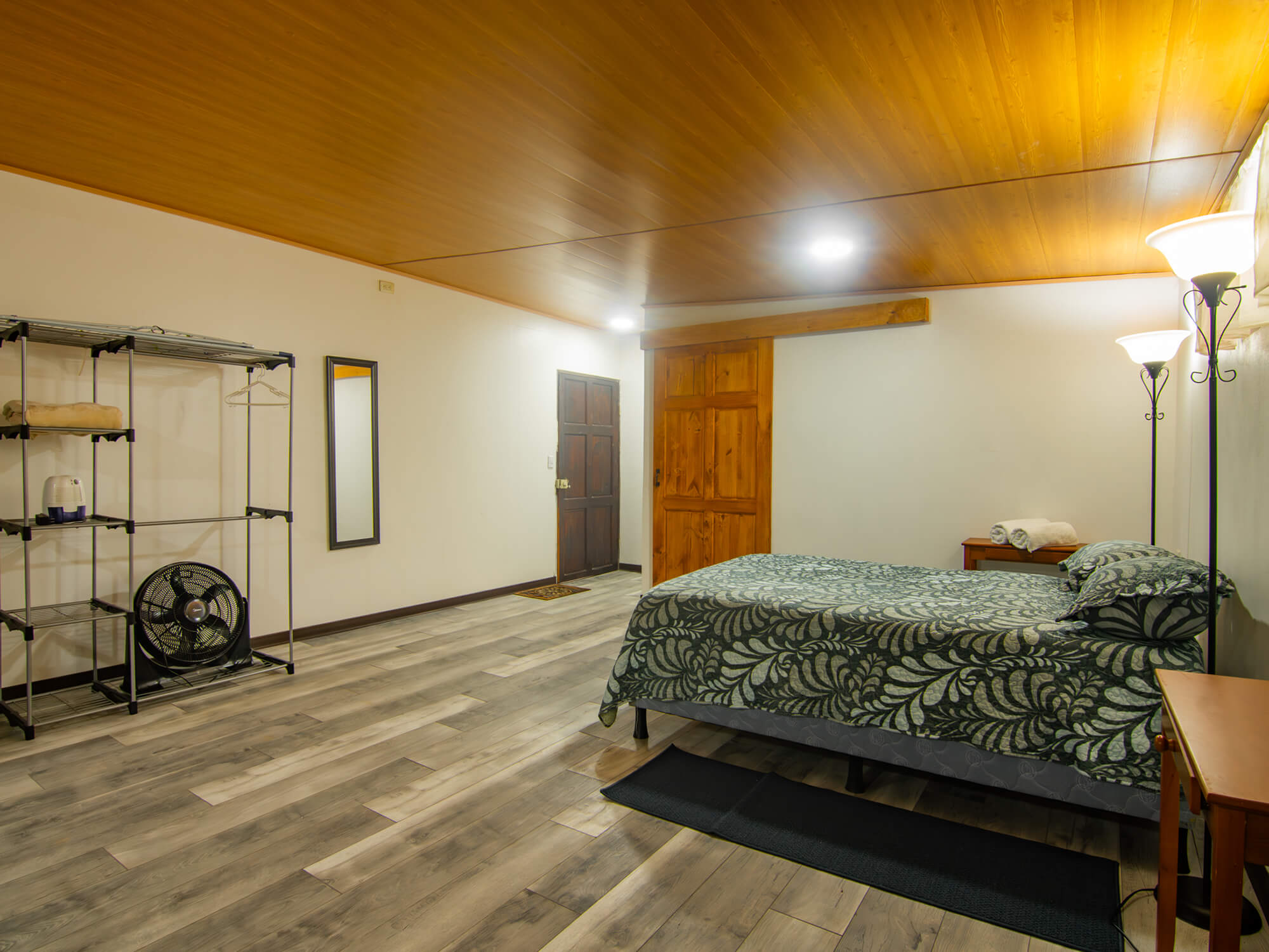 Open-plan studio showing the bed, luggage rack and wardrobe shelving