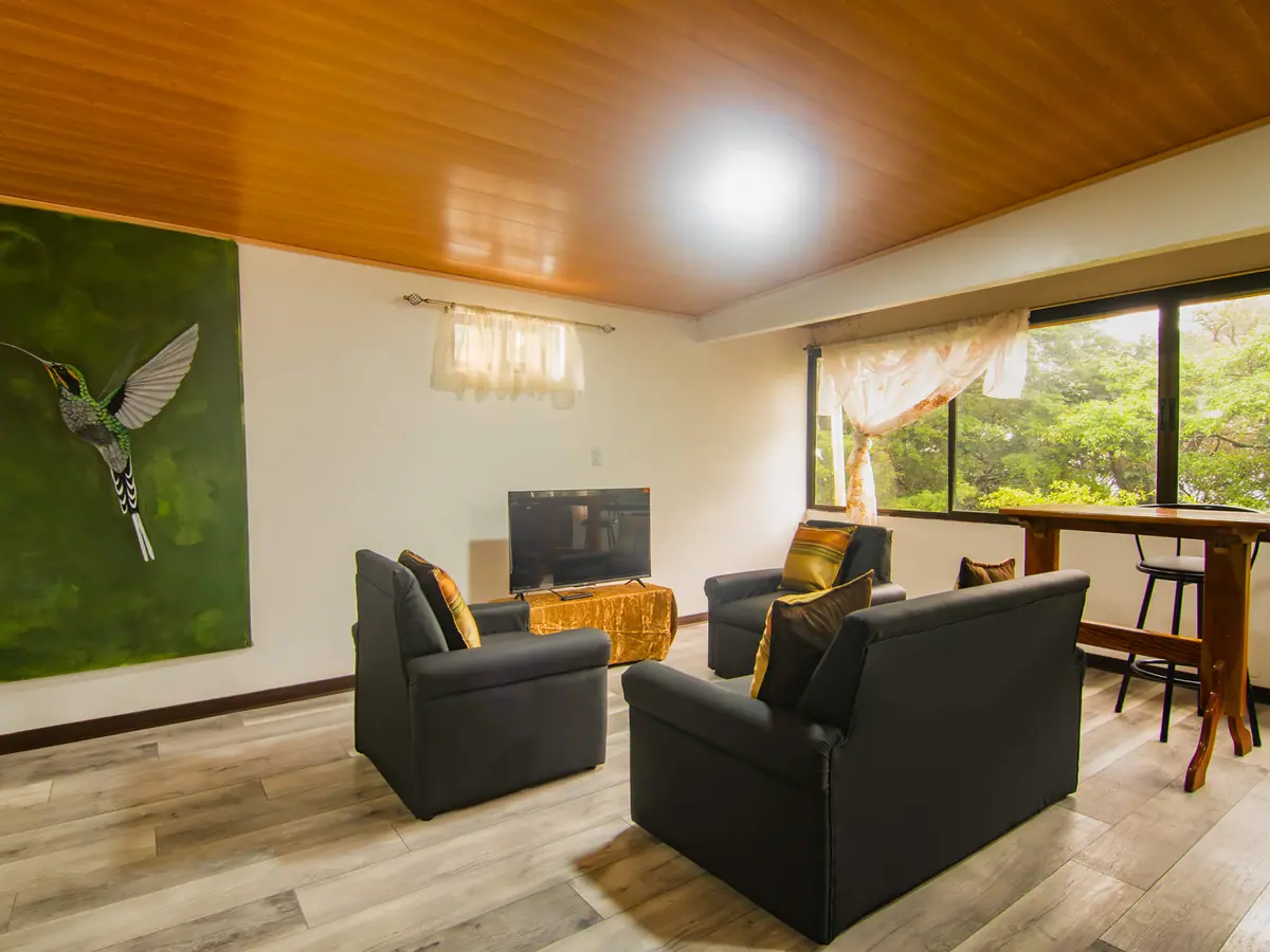 Sala frente al ventanal con vistas al bosque en el Pizote Apartment
