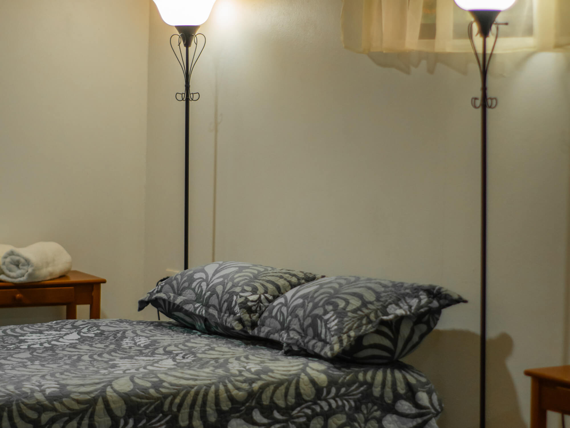 Close view of the bed linens and reading lamp in Pizote Apartment